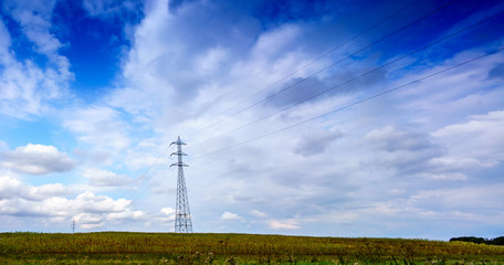 Panoramic shot of electricity pylon in field against sky with clouds, Belgium.