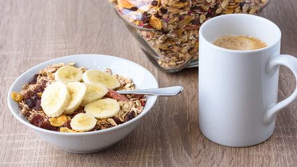Frühstück mit Kaffee und Müsli mit frischen Bananen