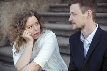 Young couple sitting on stairs on the street
