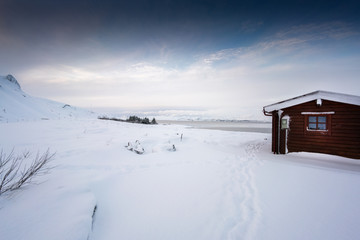 Cosy log cabin retreat in snow covered landscape, Iceland, Europe.
