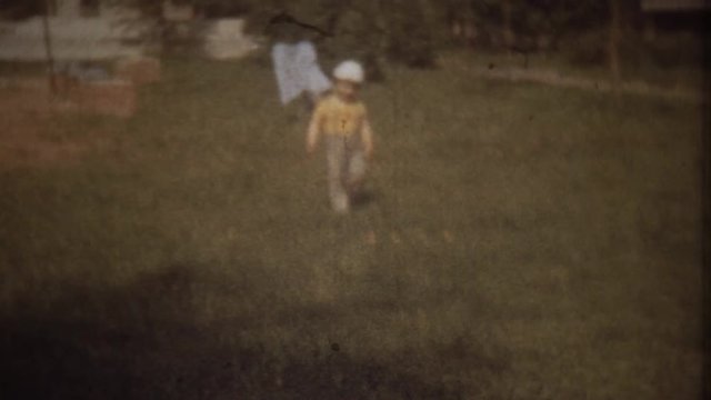 Family Chronicle: Little boy walks with his father in a city park. Father shooting video on 8mm camera