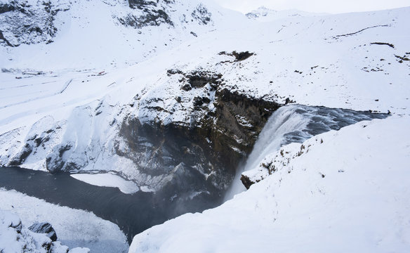 Deep snow covered landscape and waterfall by day, Iceland, Europe.