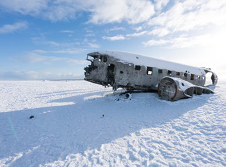 Old plane wreck on snow covered landscape by day, Iceland, Europe.