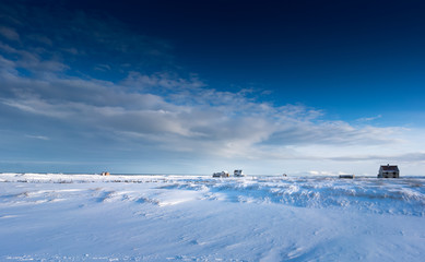 Fototapeta na wymiar Buildings situated on deep snow covered landscape, distant, Iceland, Europe.