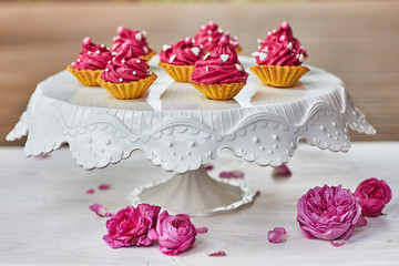 Obraz na płótnie Canvas Pink cupcakes decorated with pearls, hearts and roses
