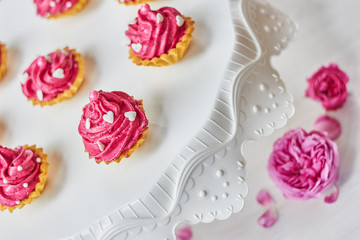 Pink cupcakes decorated with pearls, hearts and roses