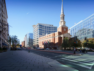 Street view of church with spire against blue sky, Washington DC, USA.