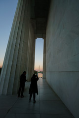 Visitors standing by large white columns, Lincoln Memorial, Washington DC, USA.