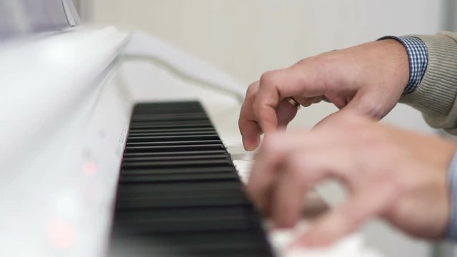 Male hands playing on white piano. Top view. UHD 4K
