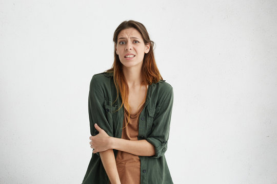 Indoor shot of confused and frowning woman with dyed hair and healthy skin dressed casually not knowing what to choose having puzzled expression. European woman expressing her negative emotions