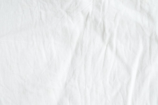 Wrinkled white cotton fabric texture background, wallpaper
