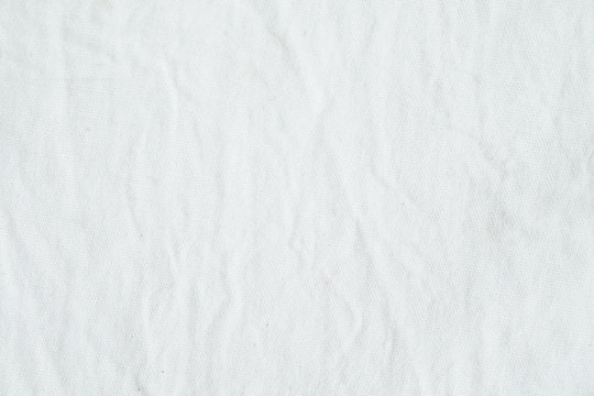 Wrinkled white cotton fabric texture background, wallpaper
