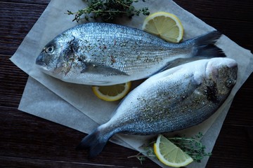 Fresh fish with lemon and thyme on a plate
