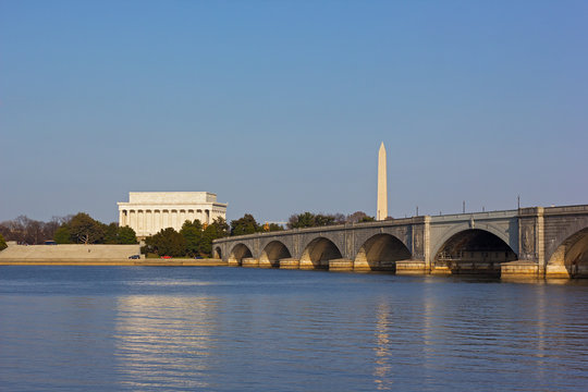 Lincoln Memorial and National Monument at sunset in Washington DC. Arlington Memorial Bridge and US capital landmarks with a view on Potomac River.