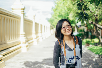 Woman tourist with camera smile in the thai temple