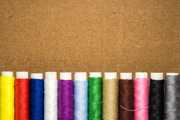 Colored thread coils on wood background