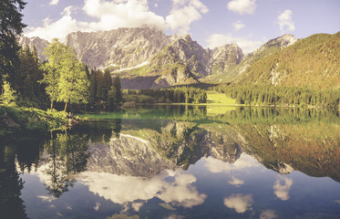 Panoramic view of beautiful white  scenery in the Alps with mountain summits reflecting in crystal clear mountain lake on a colorful dawn