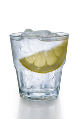 Misted glass of water with ice and slice of lemon