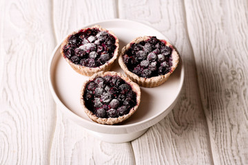 tartlets with lemon custard and blueberries on the white plate