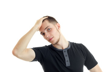 Portrait of a young guy in a black t-shirt who keeps hand behind the head