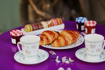 French croissants, macaroons and two cups of coffee in Parisian outdoor cafe