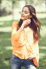 Woman with moving hair wearing casual clothes in urban background.