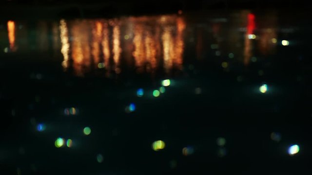 Slow motion blur beautiful light of starry night pool, illuminate fiber optic light next to restaurant 