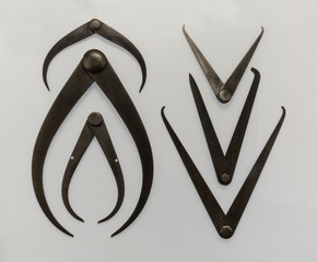 Vintage metal measuring calipers for precision engineering on white background