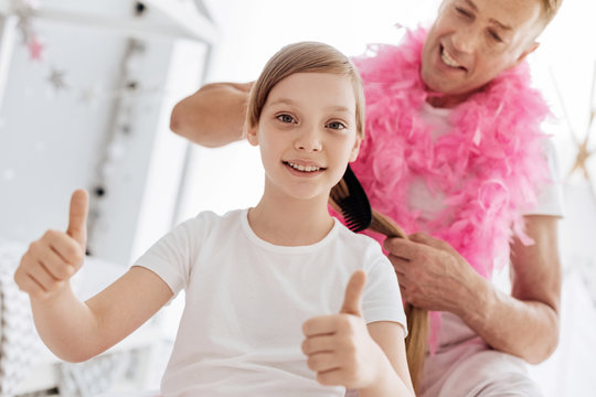 Lively Enthusiastic Girl Getting Her Hair Done By Father