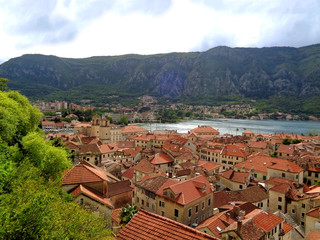 Fototapeta na wymiar Aerial view of vibrant colored tiled roofs of Kotor Old City on the shore of Kotor Bay, Kotor, Montenegro 