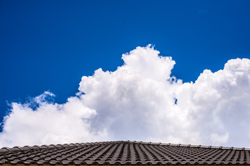 Roof  below a bright blue sky with cloud