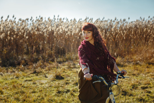Pretty girl riding bicycle in field