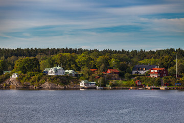 Fototapeta na wymiar View on small cabins on an island in Stockholm archipelago, Sweden. Summer sunrise time.