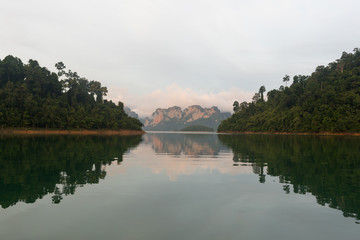 Fototapeta na wymiar A nature landscape with mountains and vegetation in the early morning on the Ratchaprapha lake in Thailand