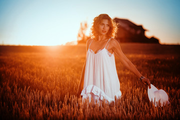 Young woman enjoy sunshine in wheat field