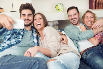 Group of trendy friends having fun in home living room