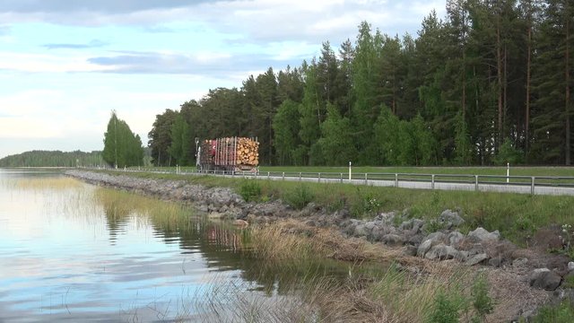 The truck rides on the highway on the coast of Saimaa lake. Finland