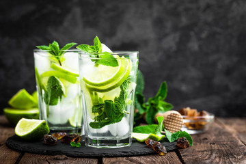 Refreshing mint cocktail mojito with rum and lime, cold drink or beverage with ice on black...