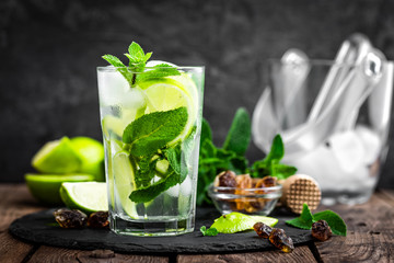 Refreshing mint cocktail mojito with rum and lime, cold drink or beverage with ice on black...