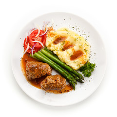 Wrapped pork chops with potatoes and asparagus on white background 
