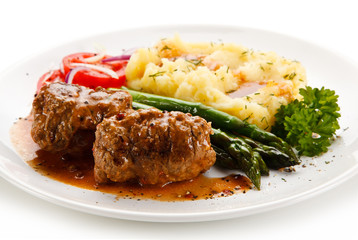 Wrapped pork chops with potatoes and asparagus on white background 