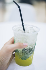 hand holding smoothie shake while walking