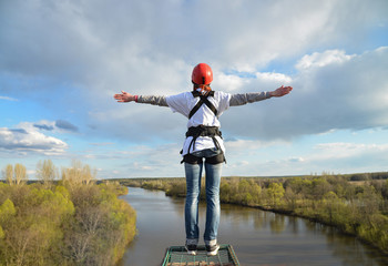 Rope jumping from high altitude of bridge. Woman standing on Platform and ready to make jump.