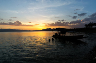 Fototapeta na wymiar Boat in the dam at sunset