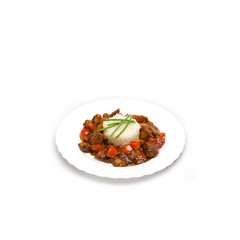 Chicken curry with rice and cilantro on white plate close up