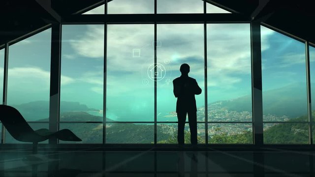 A man is standing by the window viewing IOT infographics elements