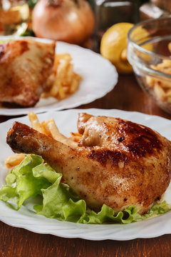 Roasted chicken legs with french fries and lettuce