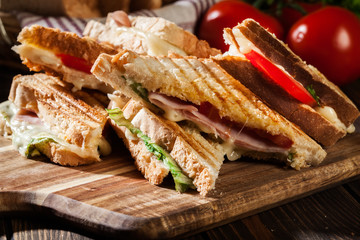 Stack of panini with ham, cheese and lettuce sandwich