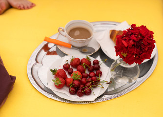 A breakfast tray with coffee on a bed.