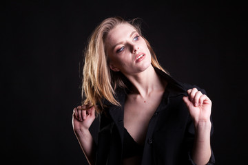 Obraz premium Beautiful blonde woman in casual fashion clothes in studio photo on black background. Sexyality and sensuality